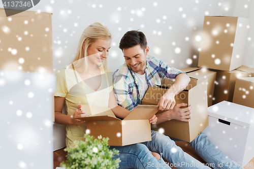 Image of smiling couple with many boxes moving to new home