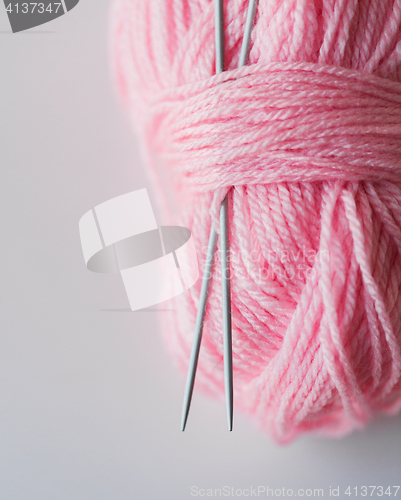 Image of close up of knitting needles and pink yarn ball 