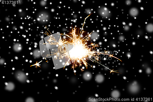 Image of sparkler or bengal light burning over black