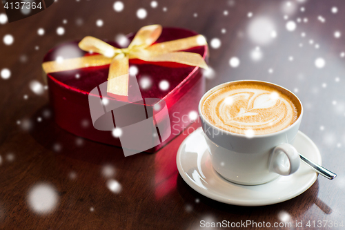 Image of close up of gift box and coffee cup on table