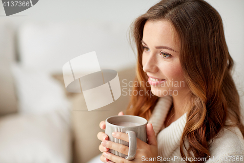 Image of happy woman with cup of cocoa or coffee at home