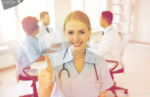 Image of happy doctor over group of medics at hospital