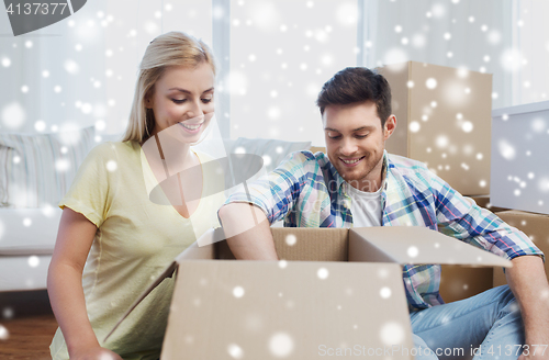 Image of smiling couple with big boxes moving to new home