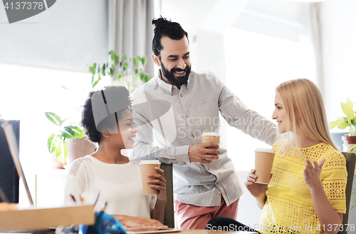Image of business team with coffee cups talking at office