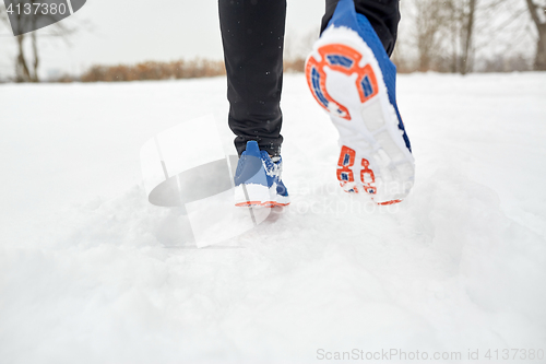 Image of close up of feet running along snowy winter road