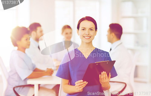 Image of happy doctor over group of medics at hospital