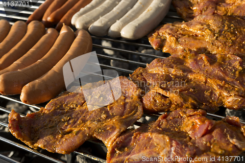 Image of Meat and sausages on a barbecue grill