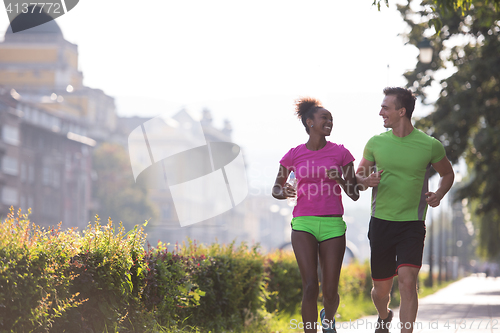 Image of young multiethnic couple jogging in the city