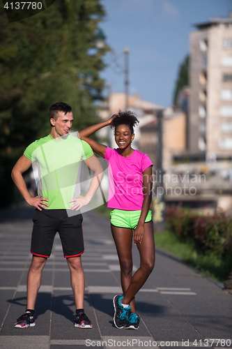 Image of portrait of young multietnic jogging couple ready to run