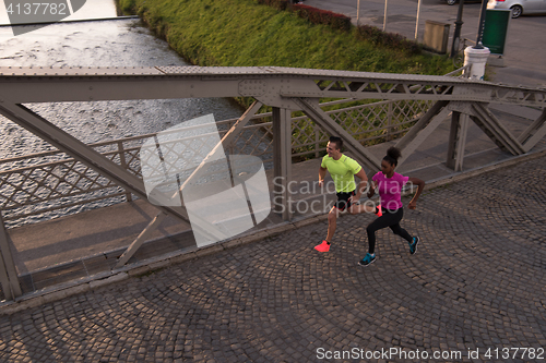 Image of young multiethnic couple jogging in the city