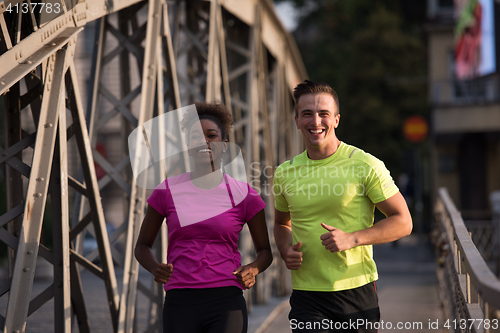 Image of multiethnic couple jogging in the city
