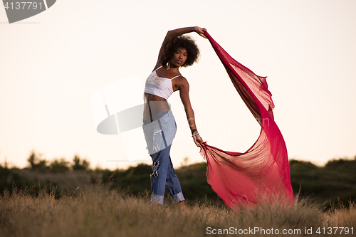 Image of black girl dances outdoors in a meadow