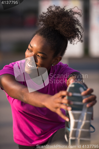 Image of African American woman doing warming up and stretching