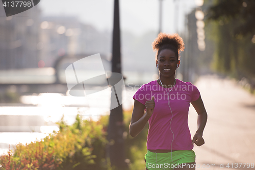 Image of african american woman jogging in the city