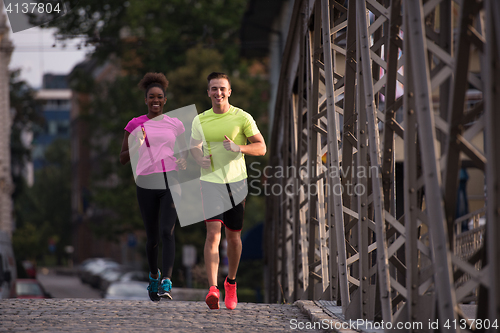 Image of multiethnic couple jogging in the city