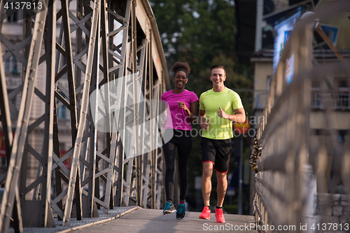 Image of multiethnic couple jogging in the city