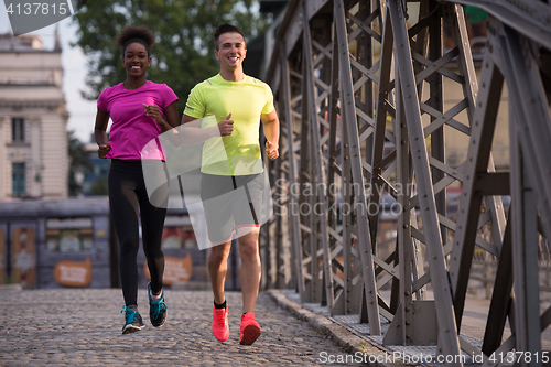 Image of multiethnic couple jogging in the city