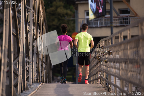 Image of multiethnic couple jogging in the city