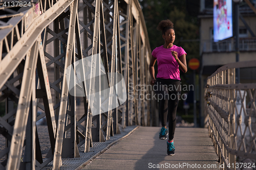 Image of african american woman running across the bridge