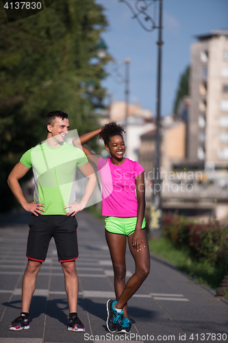 Image of portrait of young multietnic jogging couple ready to run