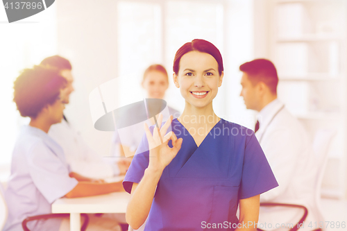 Image of happy doctor over group of medics at hospital