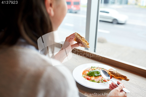 Image of woman eating gazpacho soup at restaurant