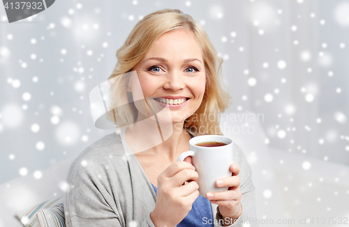 Image of smiling woman with cup of tea or coffee at home