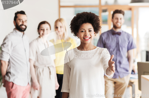 Image of woman making handshake over creative office team