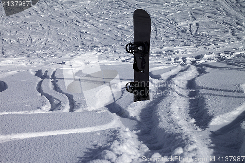 Image of Snowboard in snowdrift and off-piste slope