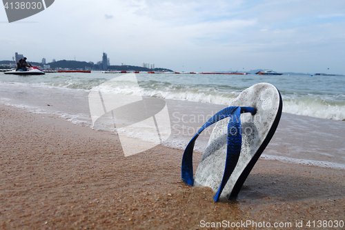 Image of Beach slippers on a sandy beach