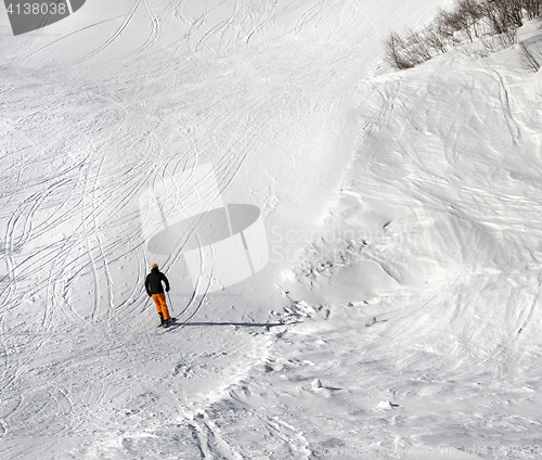 Image of Skier on ski slope at sun winter day