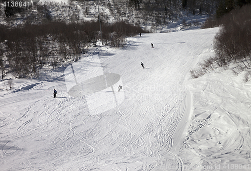 Image of Snowboarders and skiers on ski slope at winter day