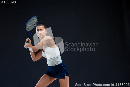 Image of Portrait of beautiful girl tennis player with a racket on dark background