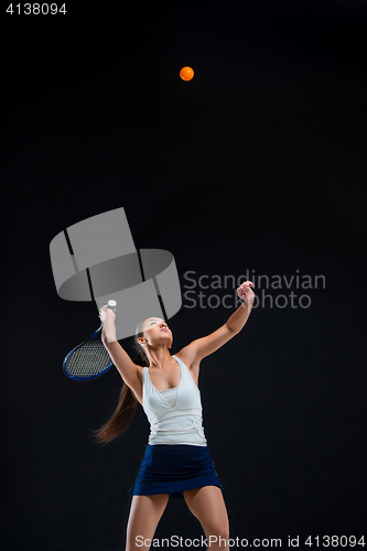 Image of Portrait of beautiful girl tennis player with a racket on dark background