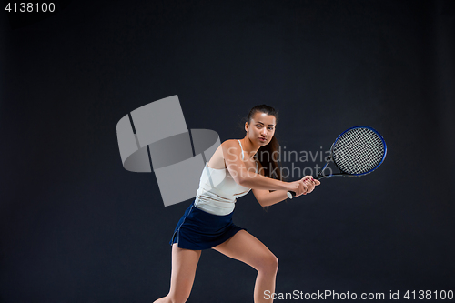 Image of Portrait of beautiful girl tennis player with a racket on dark background