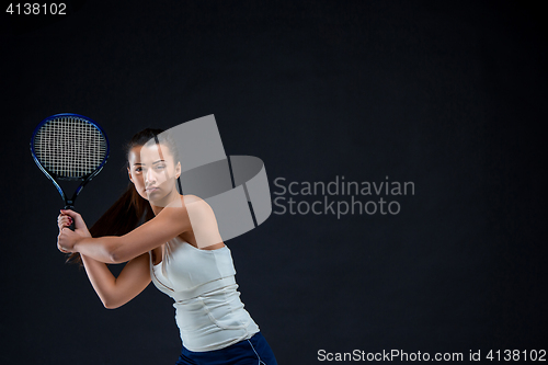 Image of Portrait of beautiful girl tennis player with a racket on dark background