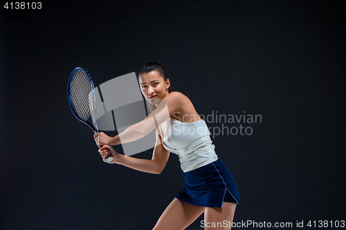 Image of Portrait of beautiful girl tennis player with a racket on dark background