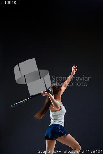 Image of Portrait of beautiful girl tennis player with a racket on dark background