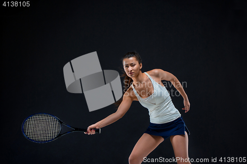 Image of Portrait of beautiful girl tennis player with a racket on dark background