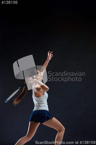 Image of Portrait of beautiful girl tennis player with a racket on dark background