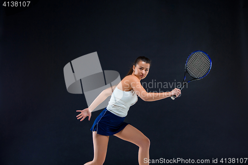 Image of Portrait of beautiful girl tennis player with a racket on dark background