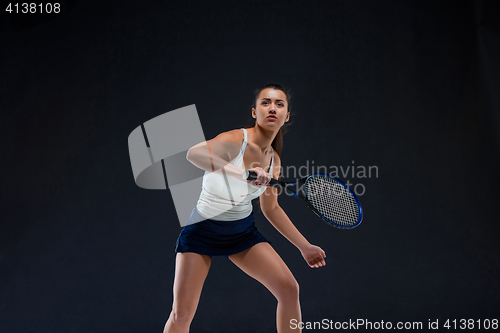 Image of Portrait of beautiful girl tennis player with a racket on dark background