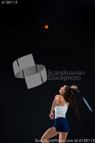 Image of Portrait of beautiful girl tennis player with a racket on dark background