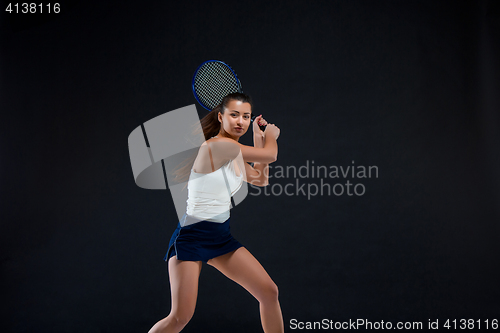 Image of Portrait of beautiful girl tennis player with a racket on dark background