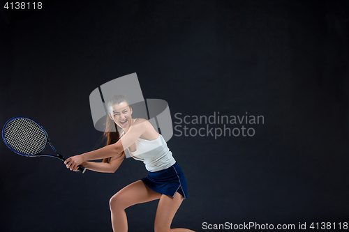 Image of Portrait of beautiful girl tennis player with a racket on dark background