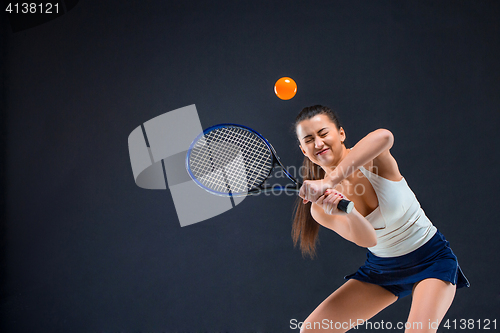 Image of Portrait of beautiful girl tennis player with a racket on dark background