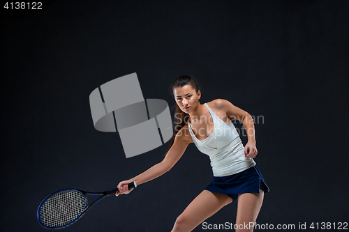 Image of Portrait of beautiful girl tennis player with a racket on dark background