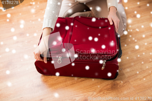 Image of close up of woman packing travel bag for vacation