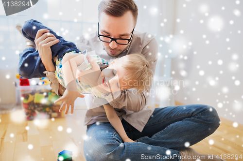 Image of father and son playing and having fun at home