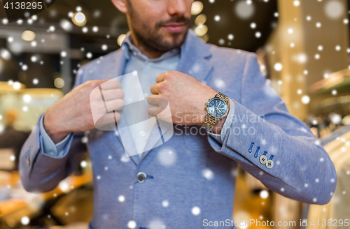 Image of close up of man trying jacket at clothing store